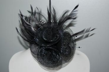 Touched shiny black hat with feathers