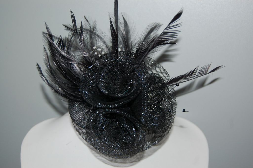 Touched shiny black hat with feathers